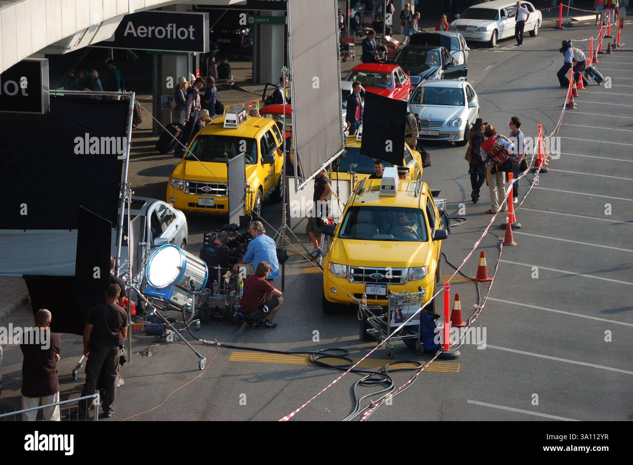 Les coulisses d'A Good Day to Die filment dur dans un aéroport. L'équipage, les caméras et l'équipement d'éclairage entourent les taxis jaunes dans la scène de mise en scène Banque D'Images