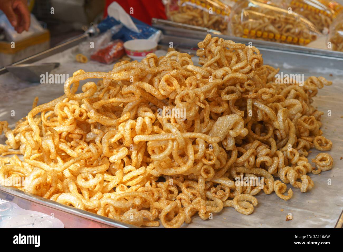Gros plan de croûtes de porc bouclées, connues localement sous le nom de Kaep Moo, frites à un brun doré et exposées sur un stand de restauration de rue. Banque D'Images