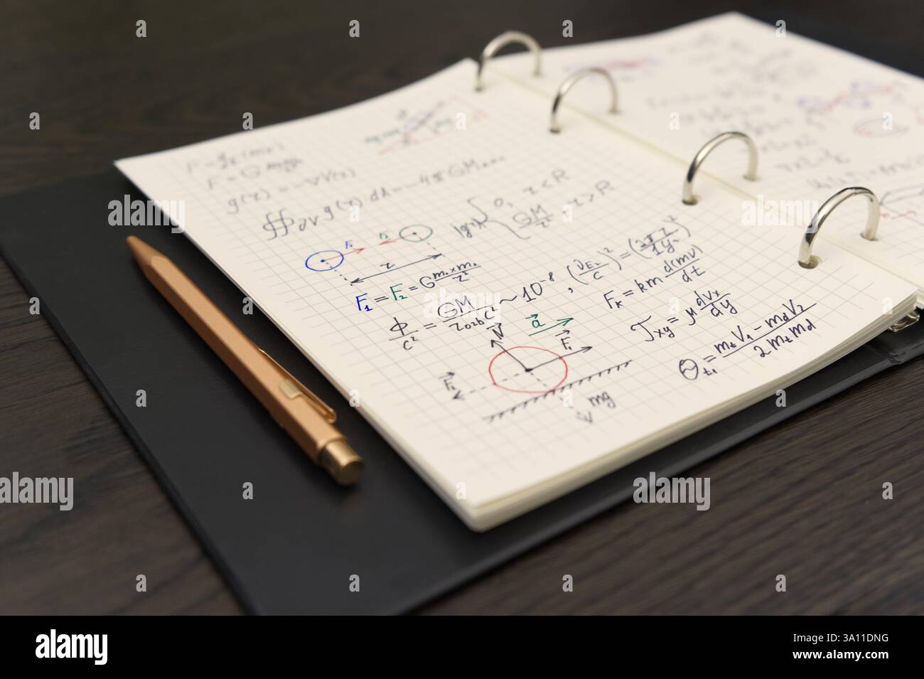 Un carnet ouvert révèle des équations mathématiques complexes et des graphiques colorés, accompagnés d'un luxueux stylo doré Banque D'Images