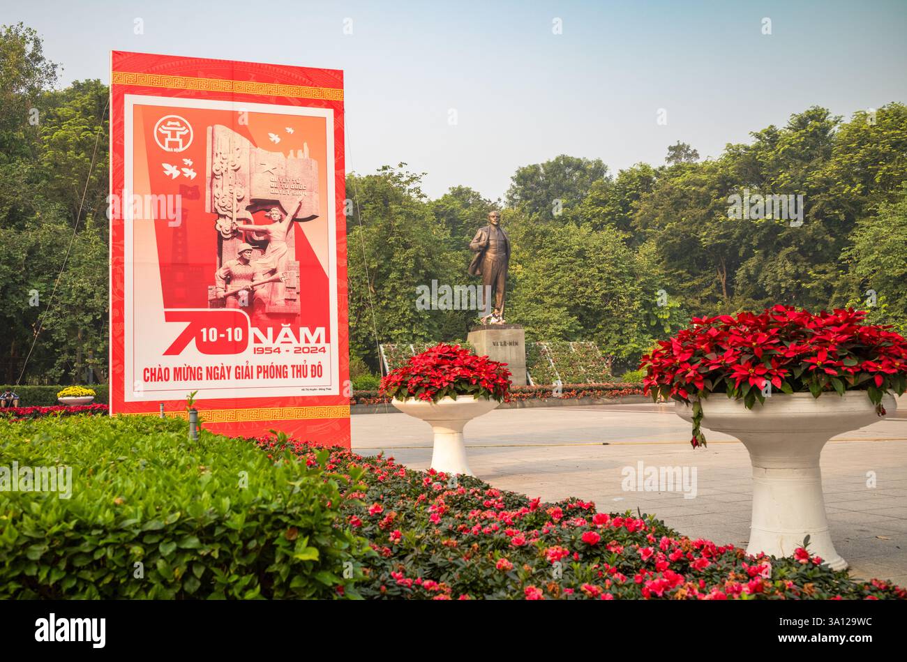 Une affiche de propagande communiste célébrant le 70e anniversaire de la libération de Hanoi des Français en 1954 à côté de la statue géante en bronze de V. Banque D'Images