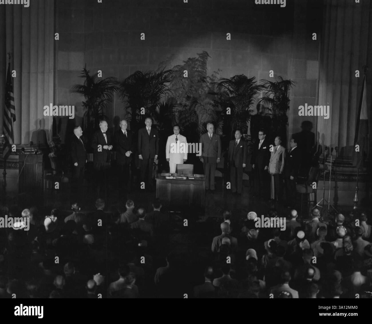 Alors que les hymnes nationaux des États-Unis et de la République des Philippines sont joués, l'Assemblée témoin de la signature du Traité de défense mutuelle est à l'honneur. Sur la plateforme, le secrétaire Acheson, le président Quirino, le président Truman, le secrétaire Ramulo, Abassador Elizalde, sénateur Francisco et représentant Macapagal. Les États-Unis d'Amérique et la République des Philippines viennent de signer un traité de défense mutuelle à Washington D.C. lors de la cérémonie de signature, dans l'auditorium du Département d'État des États-Unis, les présidents des deux Nations se sont engagés à le faire Banque D'Images