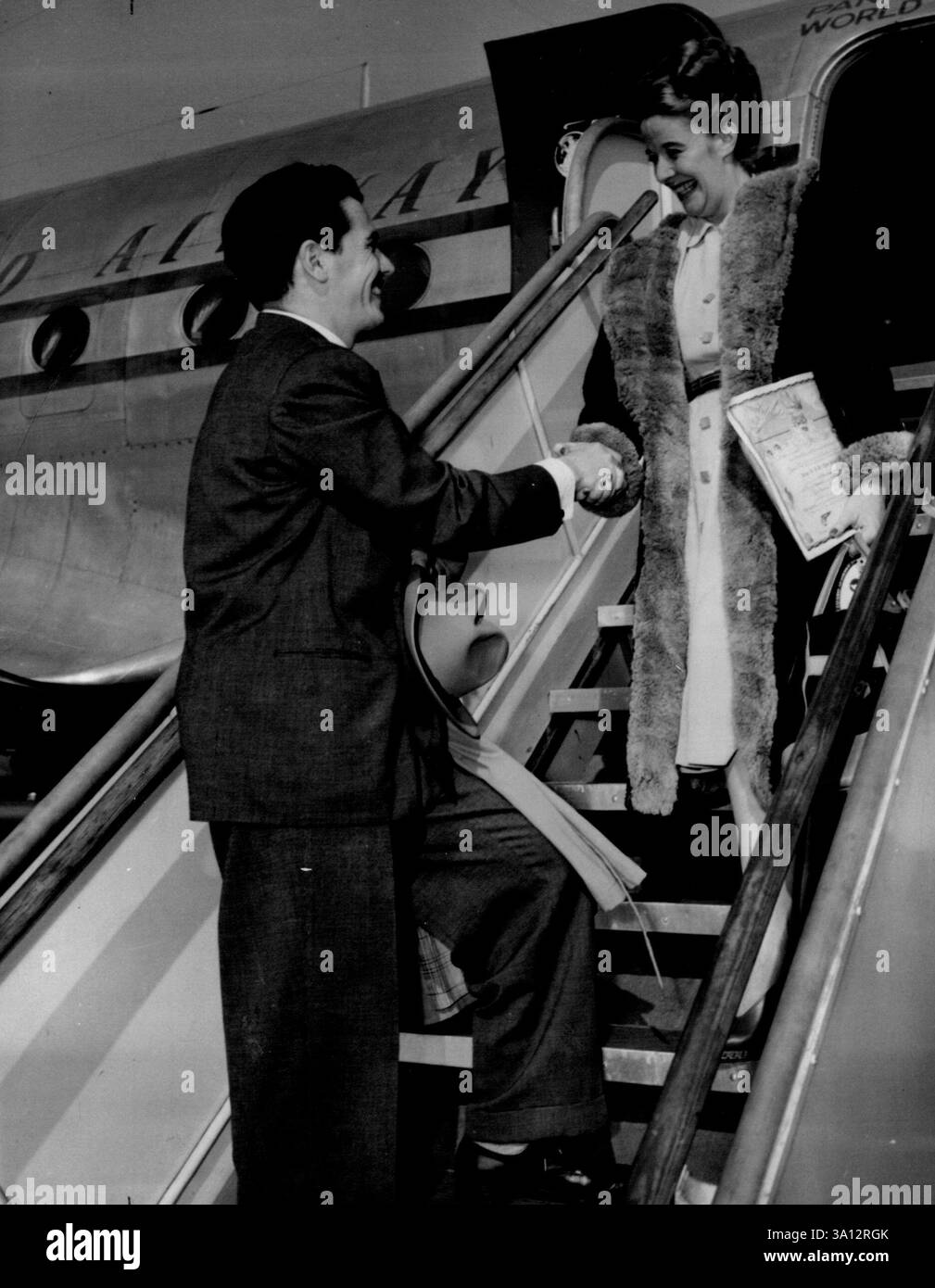 Accueil de l'Australian Star -- Ron Randell, acteur australien maintenant sous contrat avec Columbia Studio à Hollywood, Californie, accueille Kitty Bluett, Australian Star, alors qu'elle descend du Clipper au Los Angeles, Californie. Aéroport municipal. Miss Bluett, co-vedette avec Randell dans "Down Under" et "A Star in Born". 14 avril 1947. (Photo d'Associated Press photo). Banque D'Images
