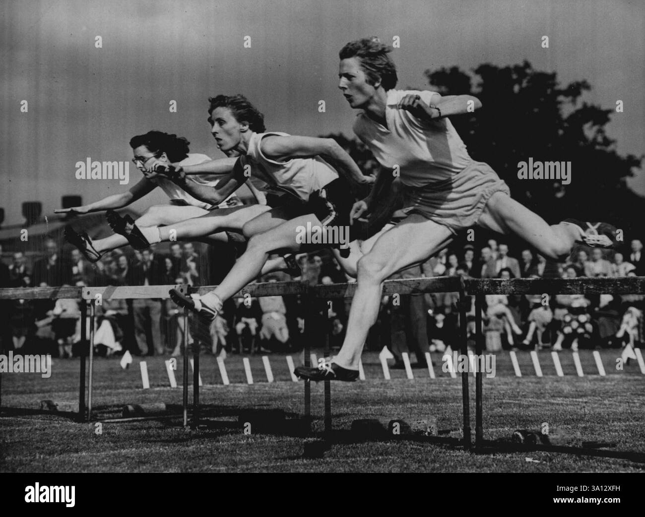 La championne néerlandaise Mrs. Fanny Blankers-Koen (caméra la plus proche) prend une légère avance sur la première haie dans une course de 80 yards à Londres. elle a gagné facilement en 11,5 secondes. 02 juin 1953. (Photo de Daily Mirror). Banque D'Images
