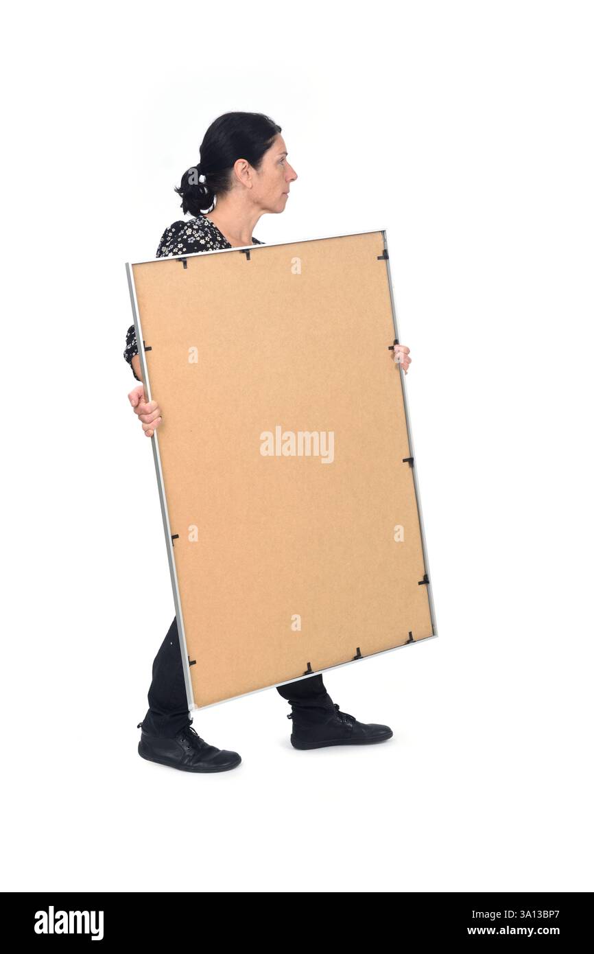 vue latérale d'une femme qui marche portant un cadre sur fond blanc Banque D'Images