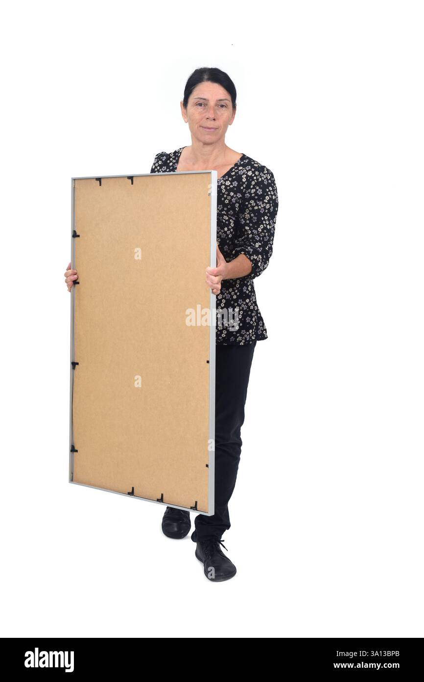 vue de face d'une femme qui marche portant un cadre sur fond blanc Banque D'Images