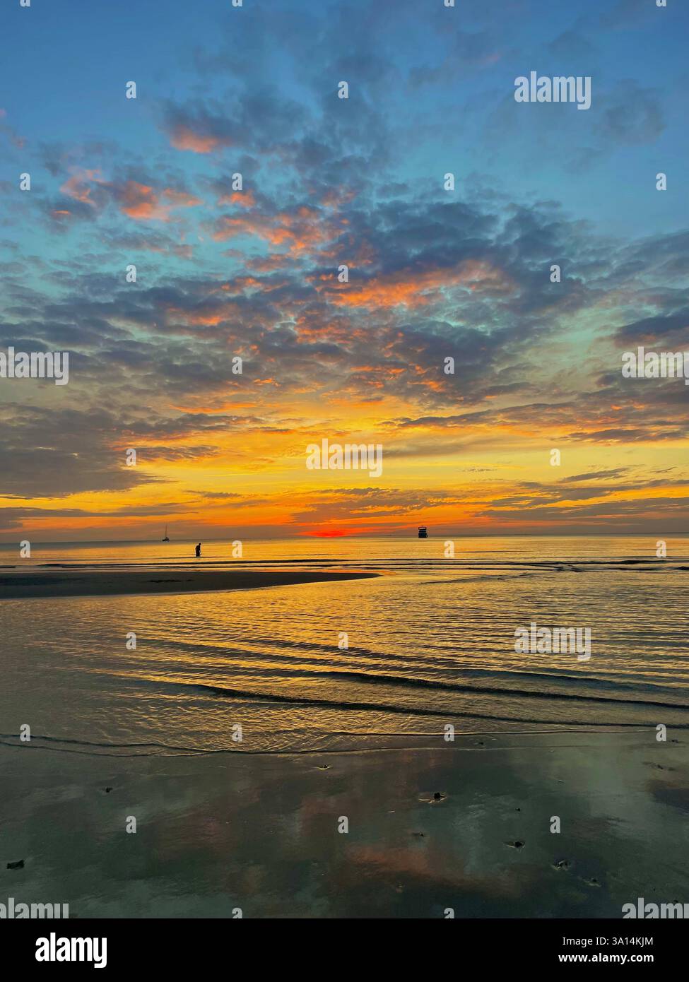 Coucher de soleil tranquille sur l'océan, peignant le ciel avec des teintes dorées et des reflets doux sur l'eau. Un moment paisible de sérénité et de wanderlust. Banque D'Images