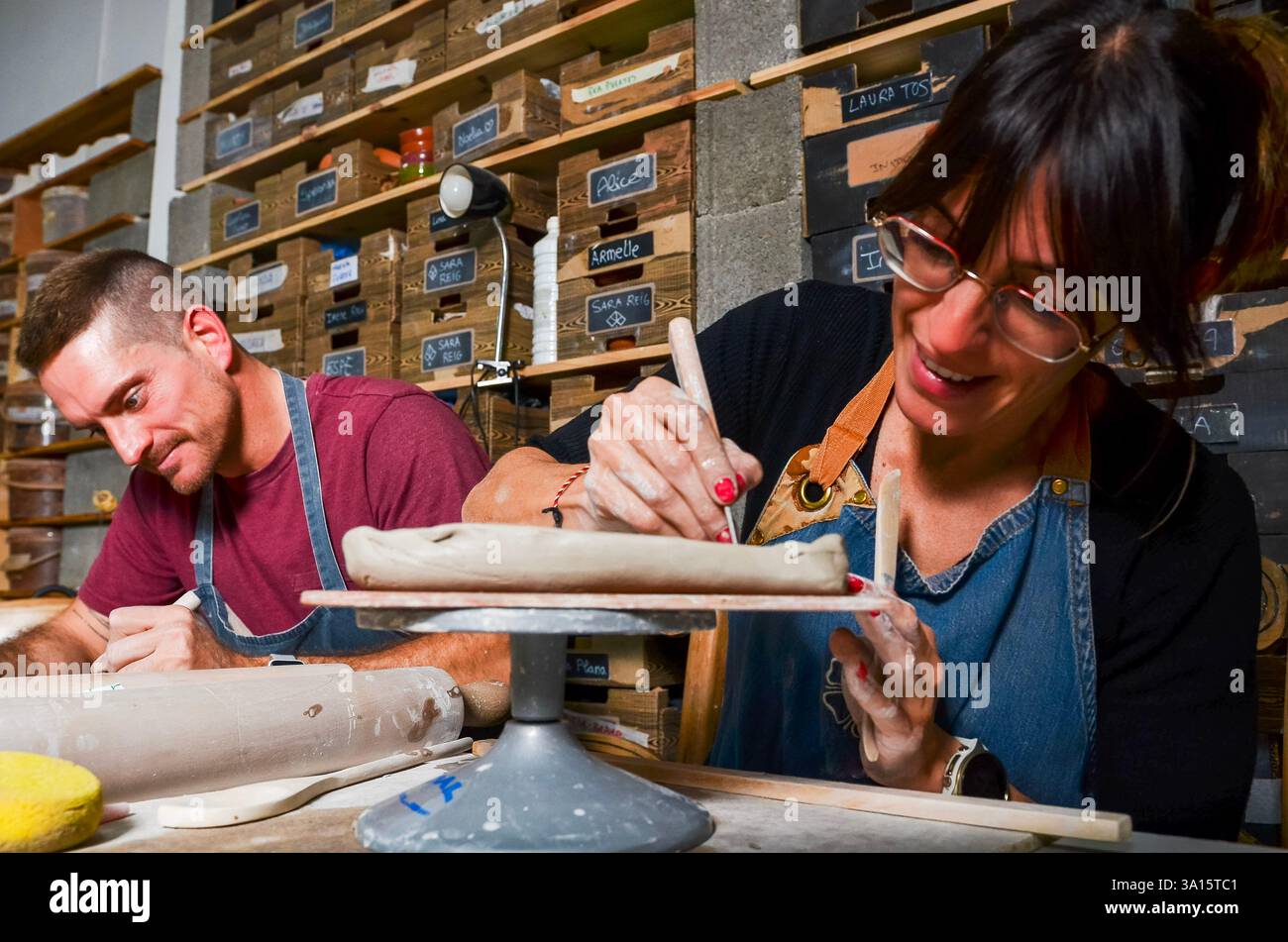 Deux artisans à modeler de l'argile dans un atelier de poterie, créant des céramiques artisanales Banque D'Images