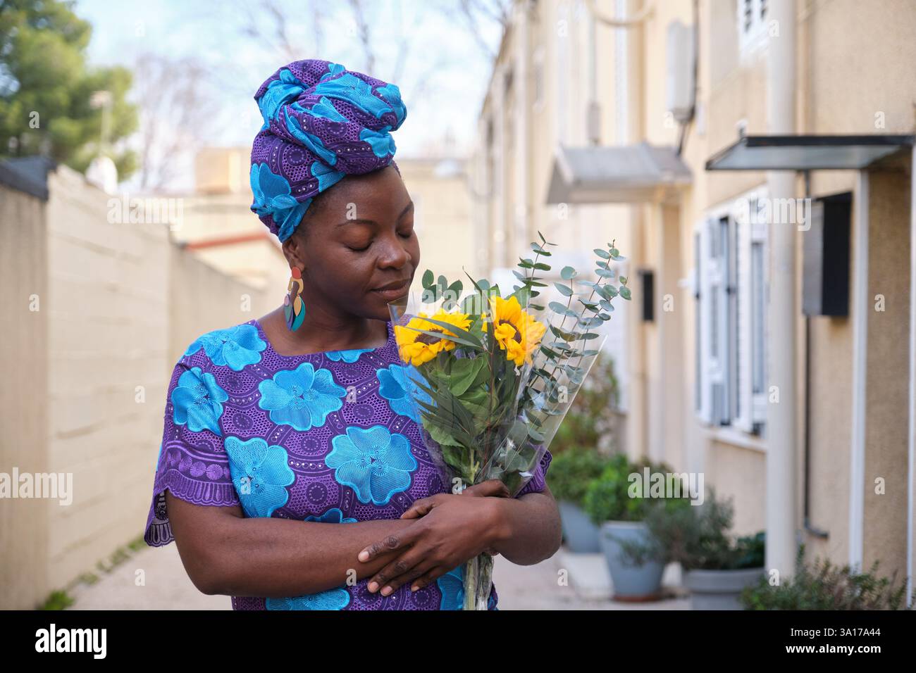 Femme sentant le tournesol et bouquet d'eucalyptus dans la rue Banque D'Images