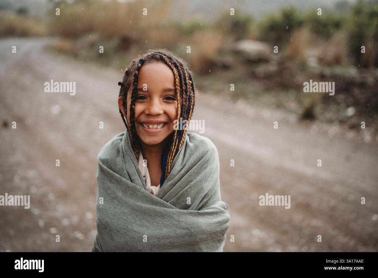 Filles noires souriantes dansant sous la pluie dans la campagne Banque D'Images