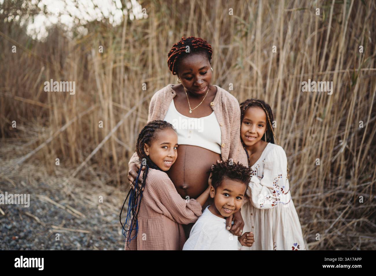 Mère enceinte noire et enfants de course mélangés touchant le ventre Banque D'Images