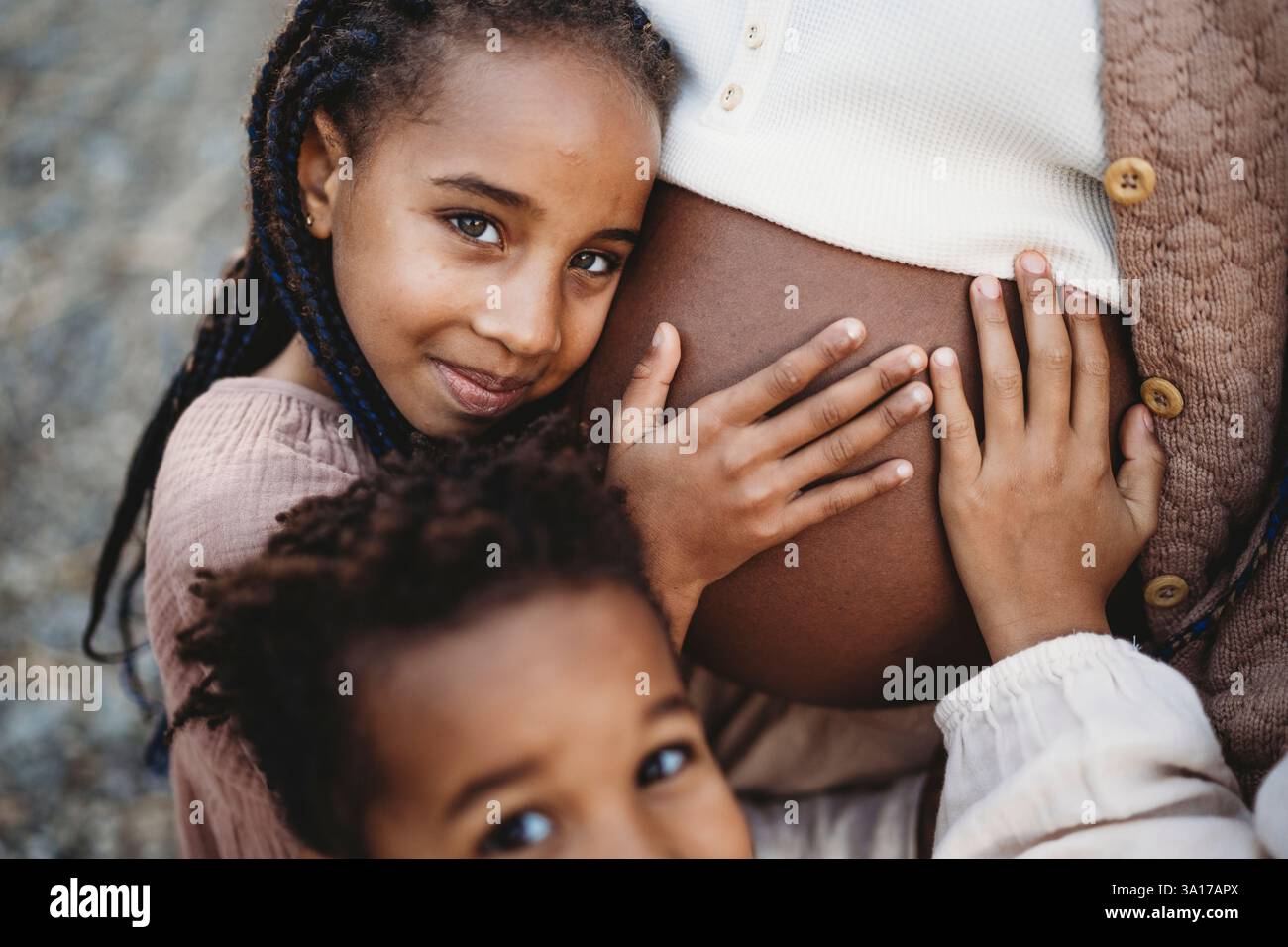 Mère enceinte noire et enfants de course mélangés touchant le ventre Banque D'Images