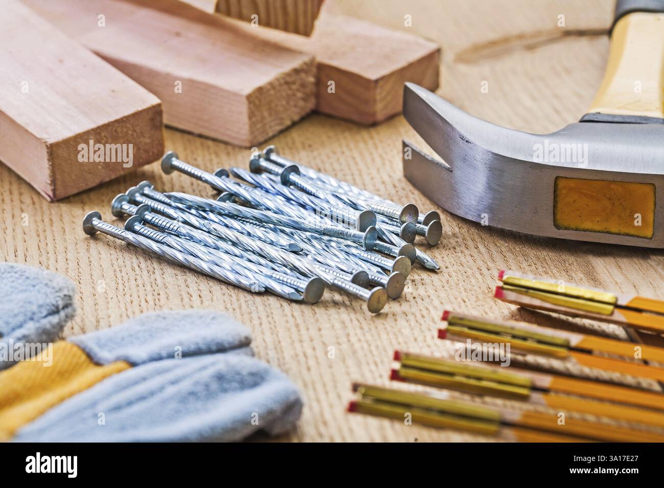Vue rapprochée sur l'ensemble d'outils de menuiserie marteau clous gant planches de mètre sur planche de bois Banque D'Images