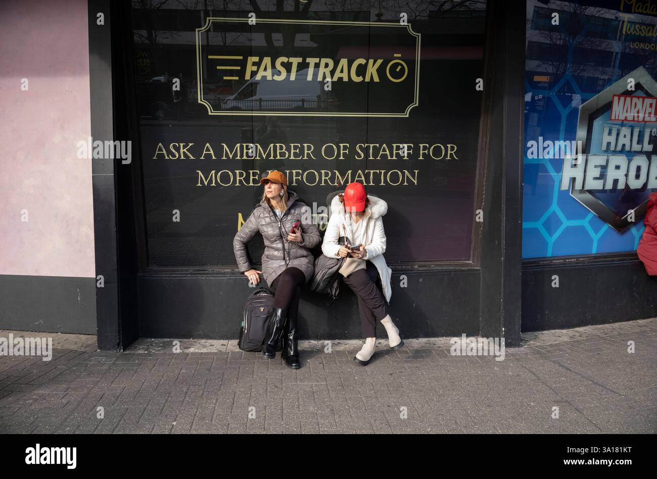Touristes assis devant Madame Tussauds, musée de cire situé sur Marylebone Road, centre de Londres, Angleterre, Royaume-Uni Banque D'Images