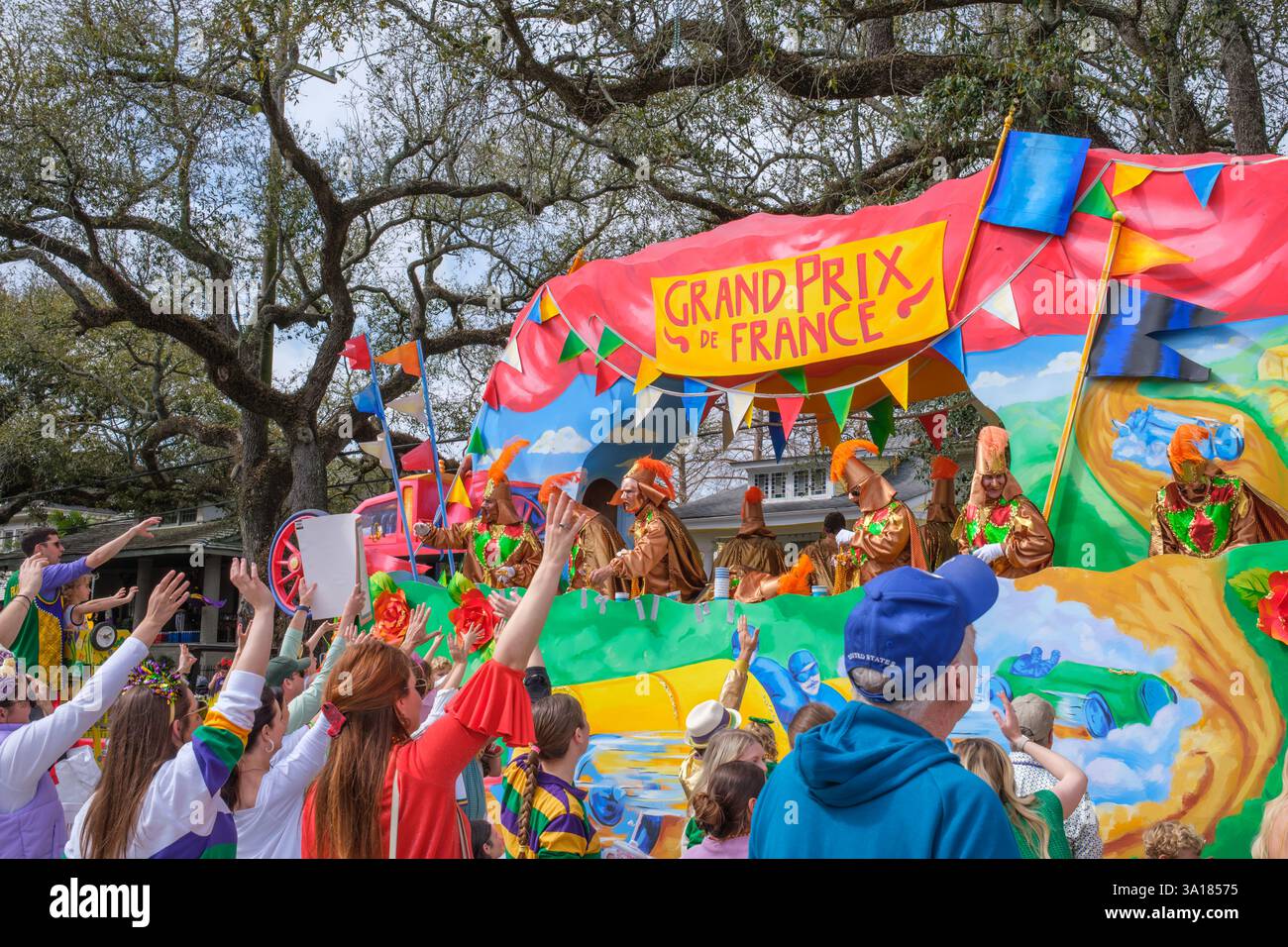 Nouvelle-Orléans, LOUISIANE, États-Unis - 4 mars 2025 : flotteur du Grand Prix de France avec des cavaliers masqués et des personnes réclamant des perles lors de la Parade Rex le jour de mardi gras sur Napoleon Avenue dans le quartier Uptown Banque D'Images