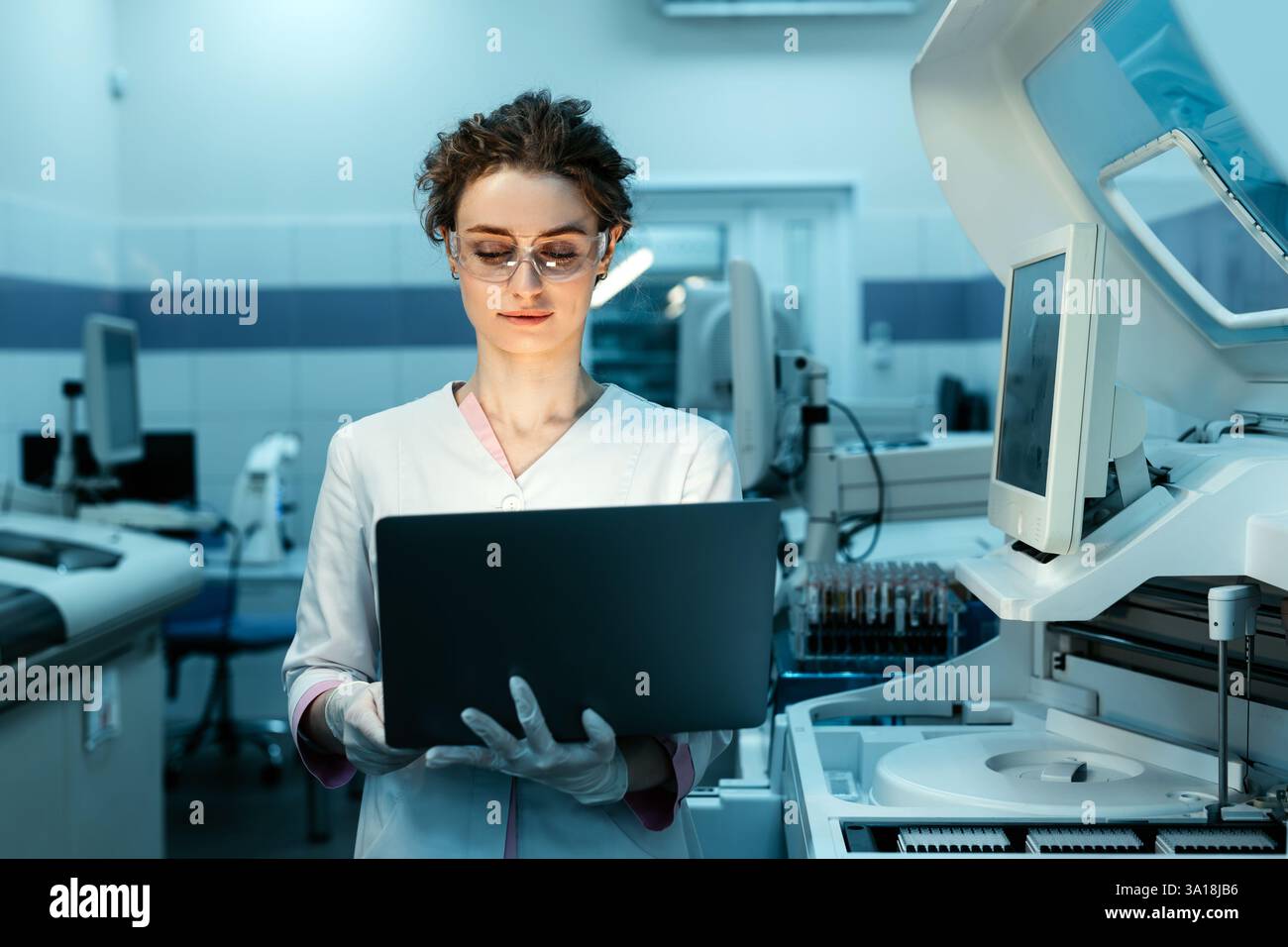 Une jeune femme ingénieur robotique avec un ordinateur portable analysant le concept d'une machine robotique dans un laboratoire de pointe. Banque D'Images