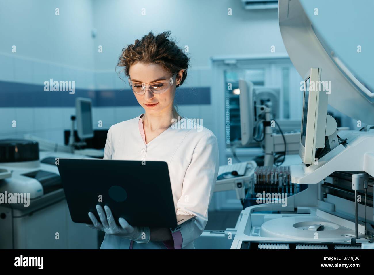 Une jeune femme ingénieur robotique avec un ordinateur portable analysant le concept d'une machine robotique dans un laboratoire de pointe. Banque D'Images