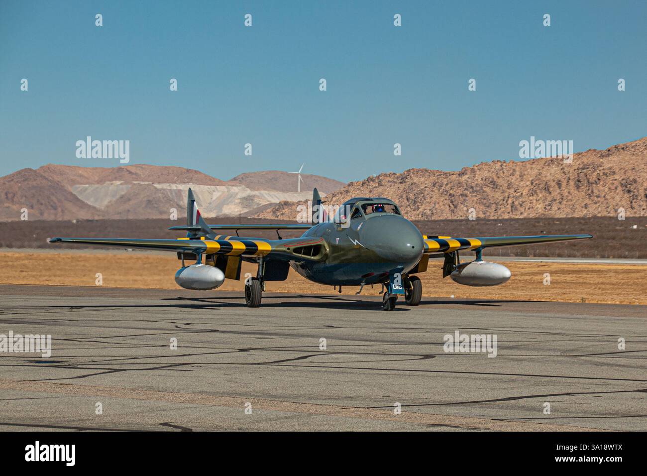 Un avion de chasse à réaction britannique vintage de Havilland Vampire taxis sur une piste d'un aéroport du désert. Banque D'Images