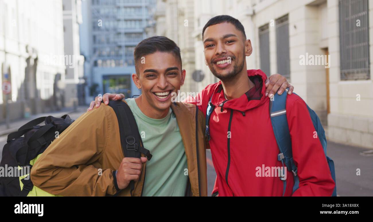Heureux couple gay biracial embrassant dans la rue Banque D'Images