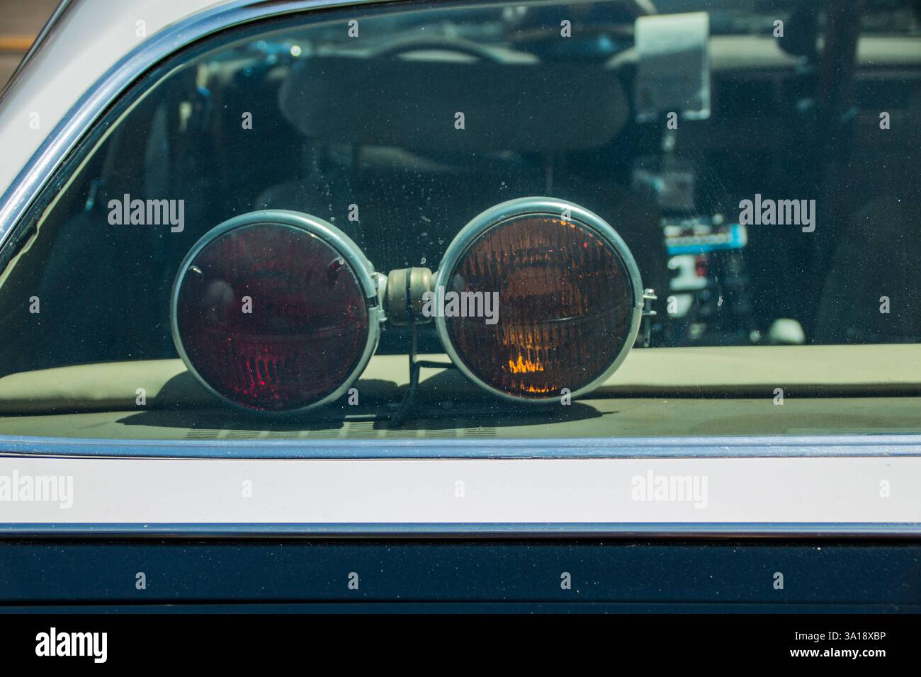 Feux de pont arrière rouges et ambres dans une voiture de patrouille routière californienne d'époque. Banque D'Images