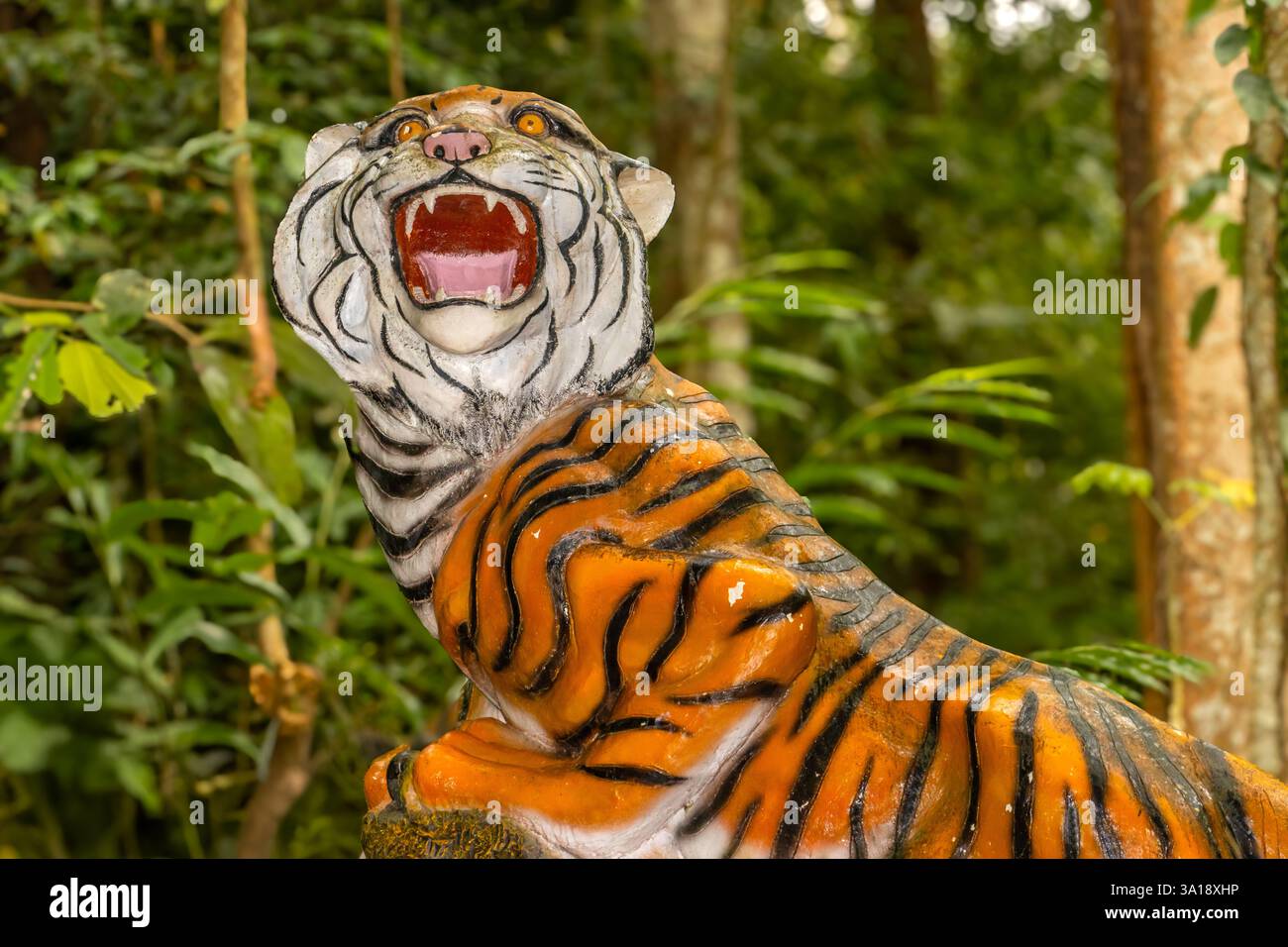 Statue d'un tigre rugissant dans une forêt tropicale Banque D'Images