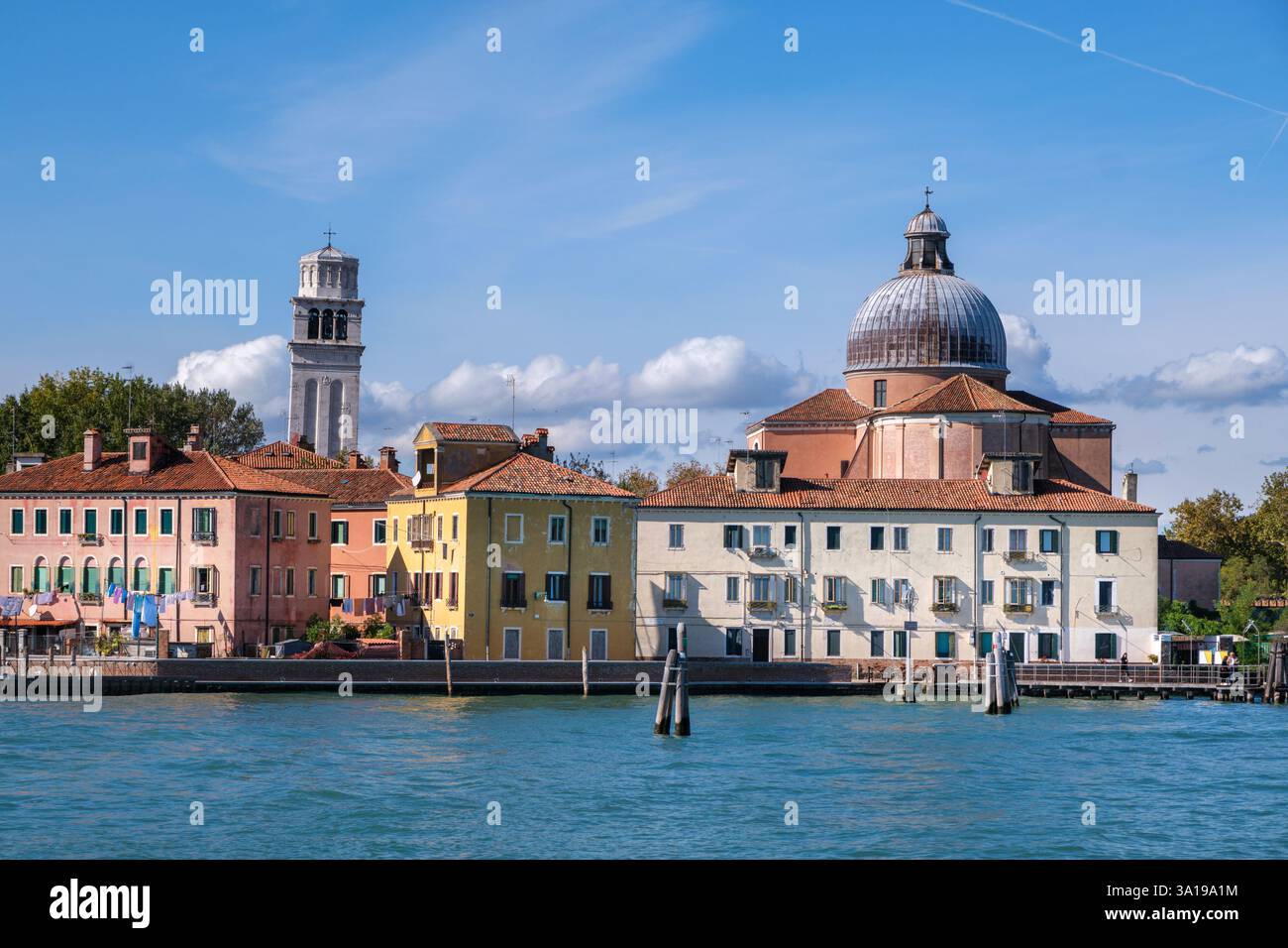 Venise, Italie - 12 octobre 2024 : la Basilica di San Pietro di Castello et son clocher historique se dressent contre un ciel bleu vif, avec Ven coloré Banque D'Images