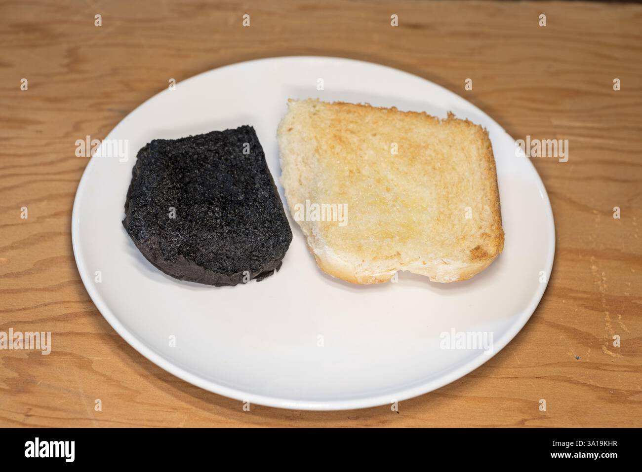 pain brûlé grillé et complètement carbonisé assis sur une assiette blanche Banque D'Images