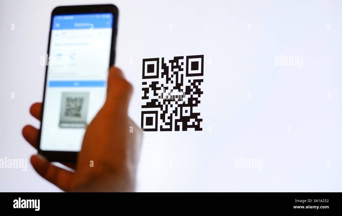 Scannez le code QR avec le smartphone sur l'écran de l'ordinateur. Banque D'Images