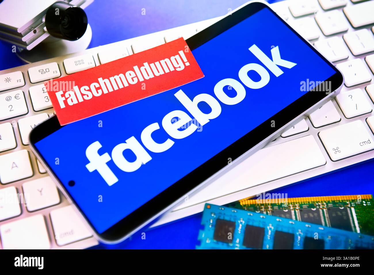 Smartphone avec logo Facebook sur un clavier d'ordinateur et un morceau de papier avec l'inscription faux rapport Banque D'Images