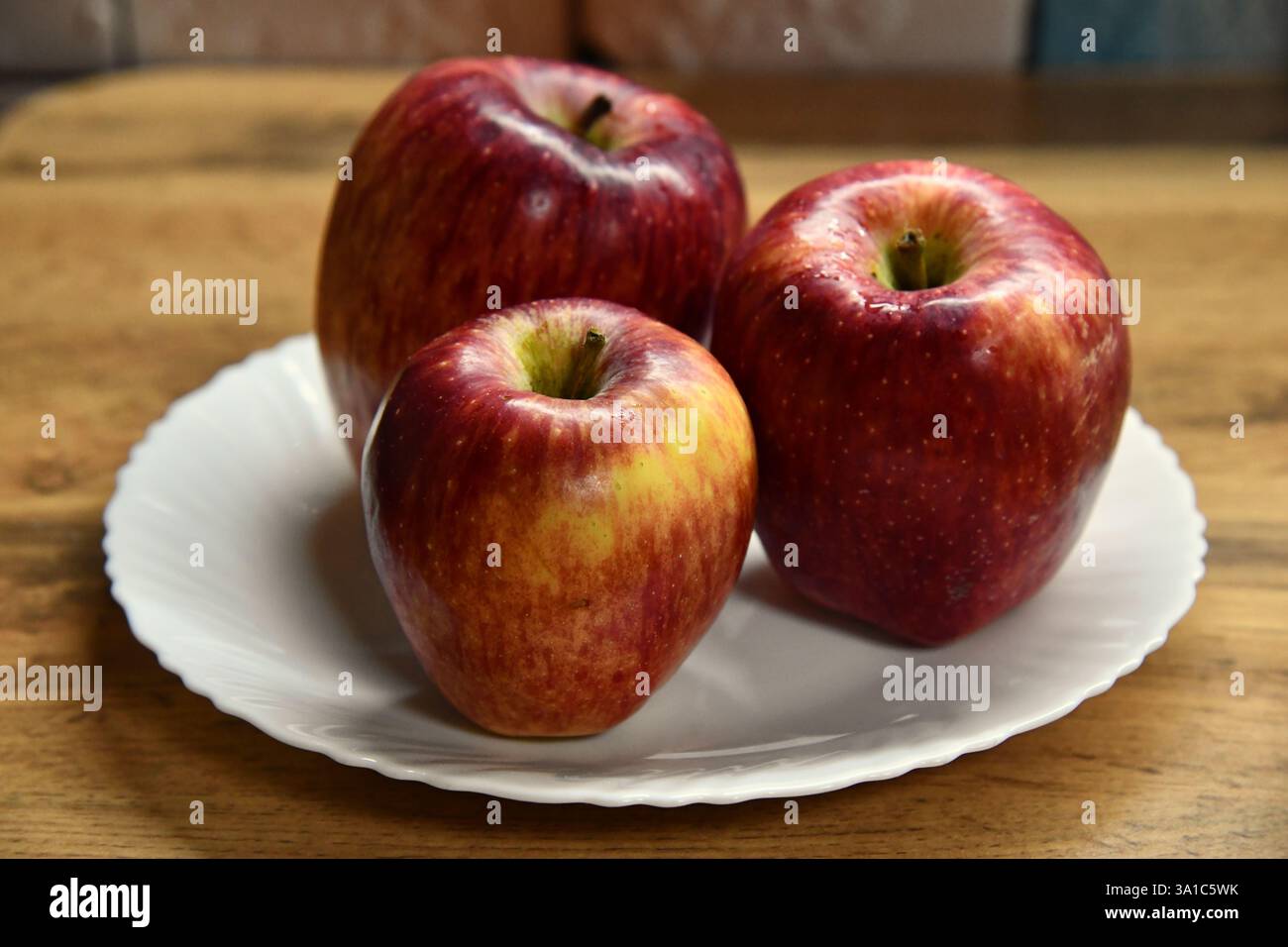 Assiette avec des pommes et des feuilles d'automne sur une table en bois Banque D'Images