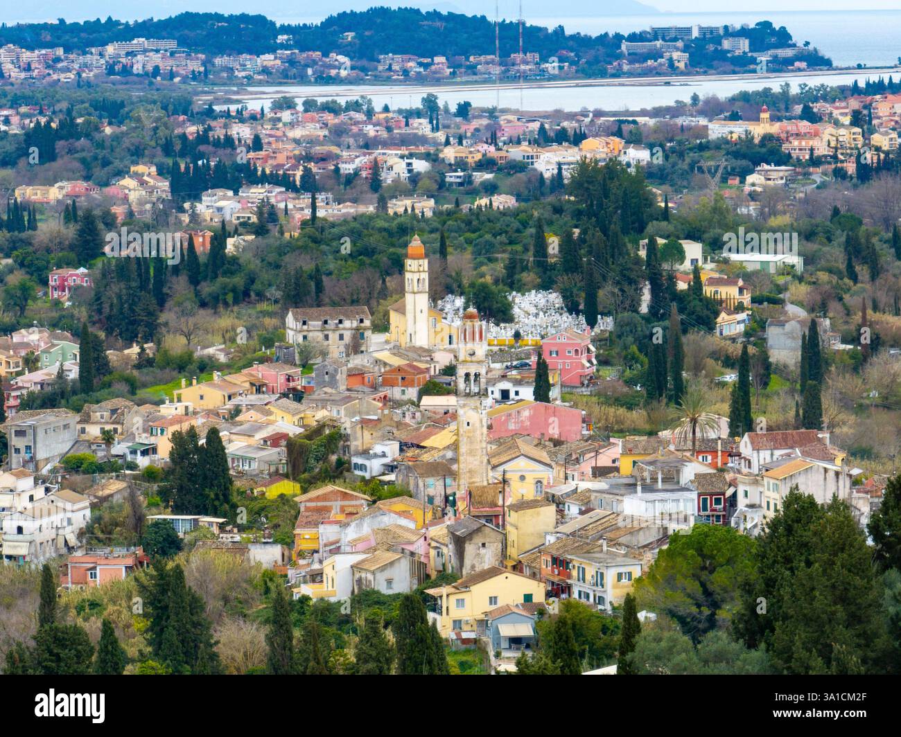 Pittoresque ville européenne nichée parmi les arbres verts et le feuillage près de la mer et des collines lointaines Banque D'Images