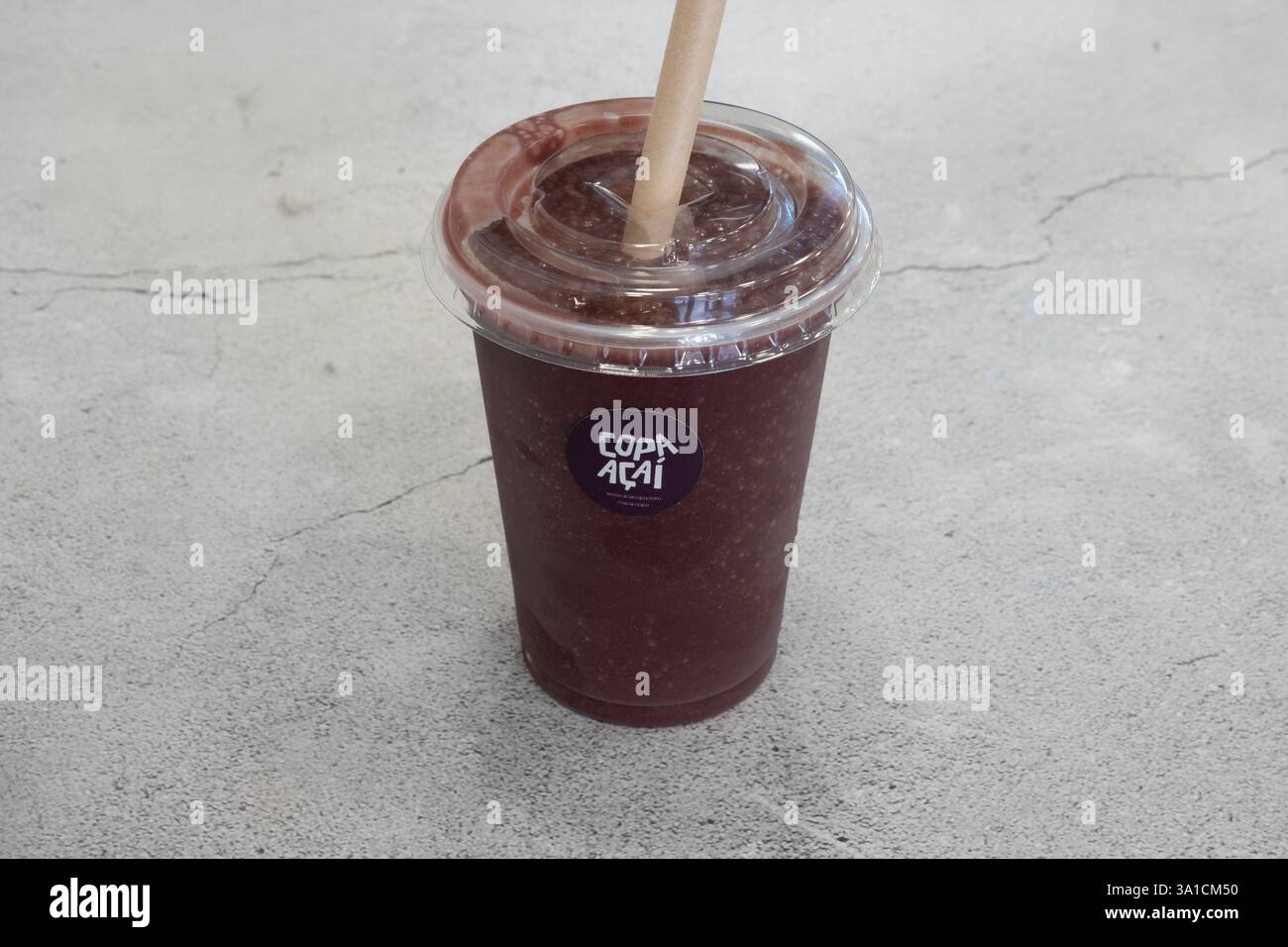 Une tasse de café avec une paille dedans. La tasse est étiquetée avec le mot « café » et porte un autocollant violet Banque D'Images