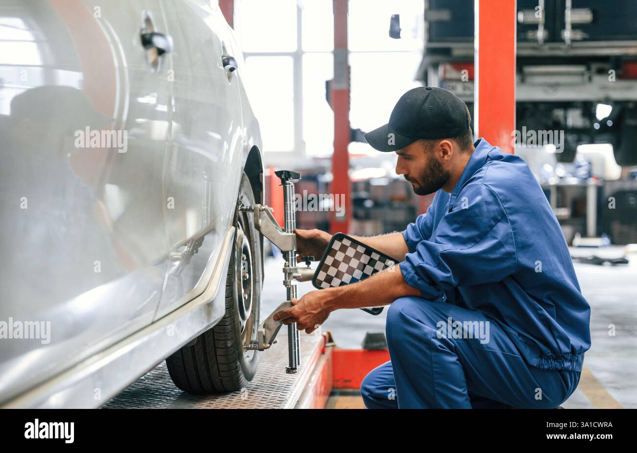 Prendre soin du disque de roue. Mécanicien automobile travaillant dans le garage. Service de réparation. Banque D'Images