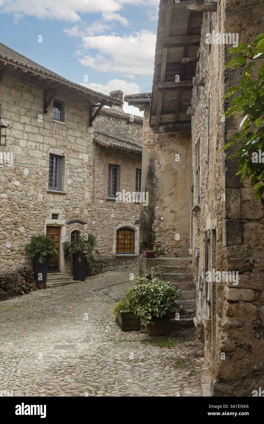 Des maisons en pierre austères bordent une rue pavée de Pérouges médiévale, l'un des 'plus beaux villages de France'. Banque D'Images