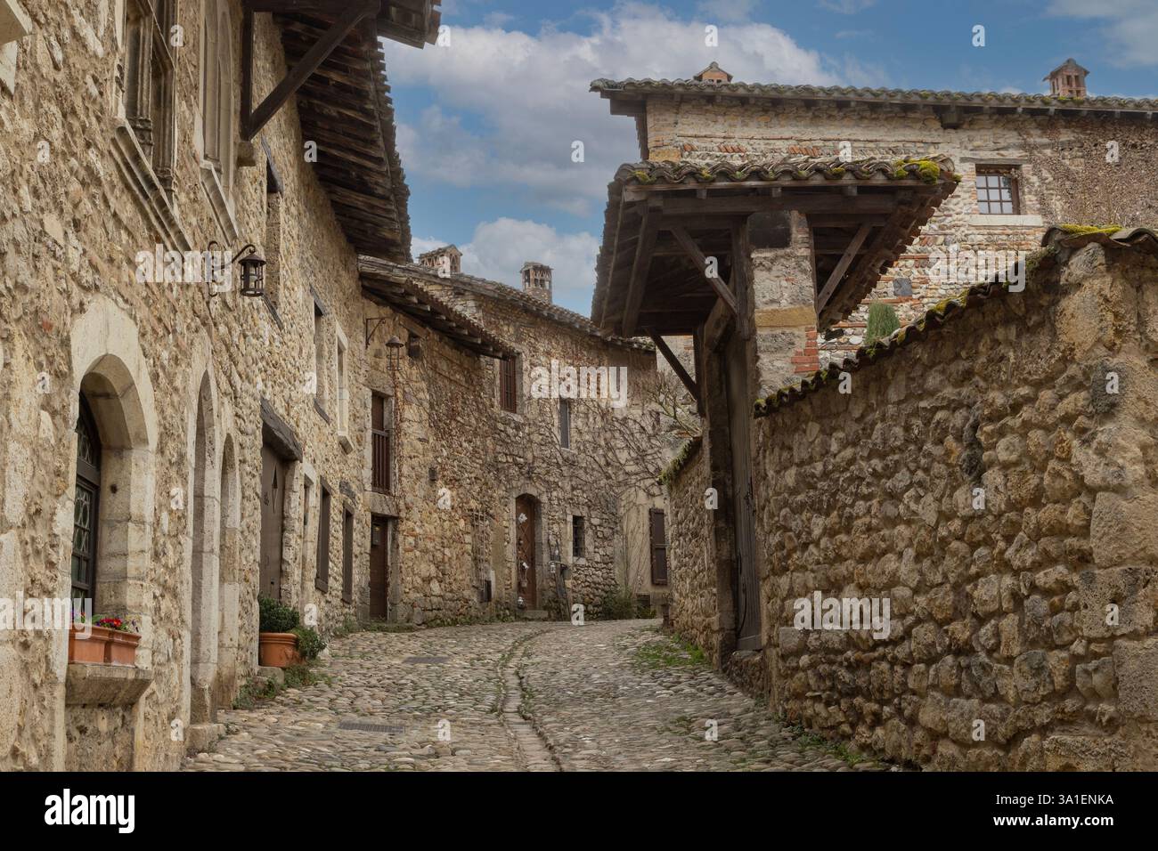 Une rue pavée bordée de maisons en pierre austères dans le Pérouges médiéval, l'un des 'plus beaux villages de France'. Banque D'Images