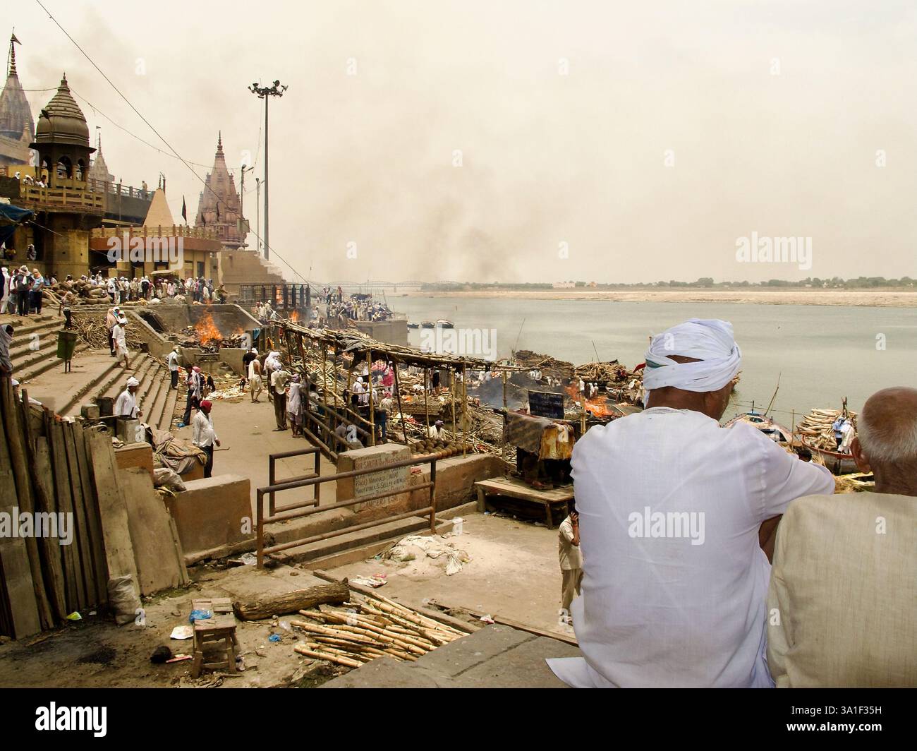 Crémations en cours à Manikarnika Ghat, Varanasi, alors que les personnes en deuil regardent à travers le Gange - l'un des lieux funéraires les plus sacrés de l'hindouisme. Banque D'Images Crémations en cours à Manikarnika Ghat, Varanasi, alors que les personnes en deuil regardent à travers le Gange - l'un des lieux funéraires les plus sacrés de l'hindouisme. Banque D'Images