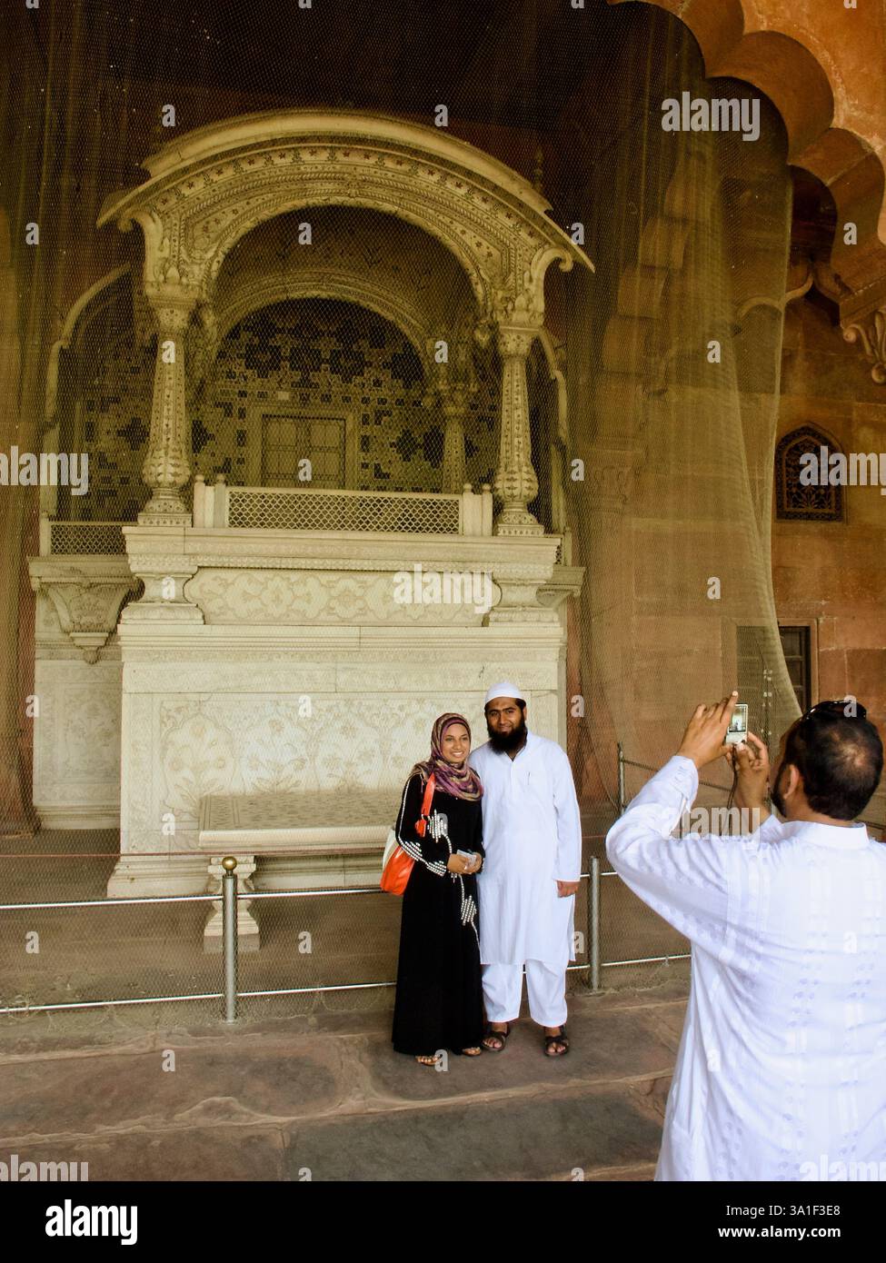 Les visiteurs posent pour une photo devant la canopée du trône de marbre dans le Diwan-i-AAM, Fort Rouge, New Delhi, Inde. Banque D'Images