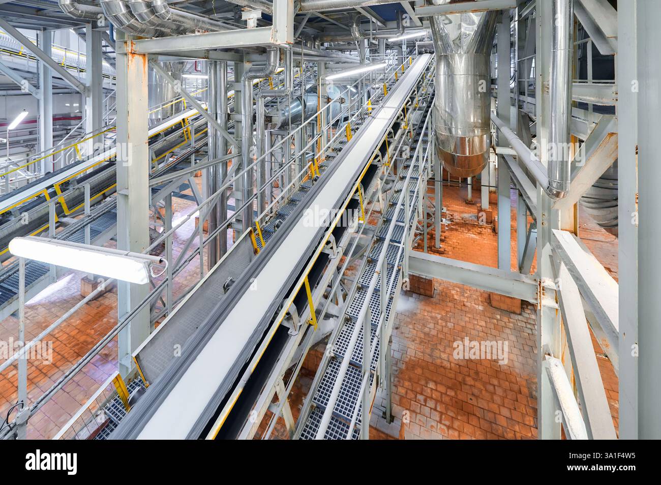 Vue détaillée du système de convoyage d'une usine chimique avec pipelines illustrant les processus industriels pendant les opérations diurnes Banque D'Images