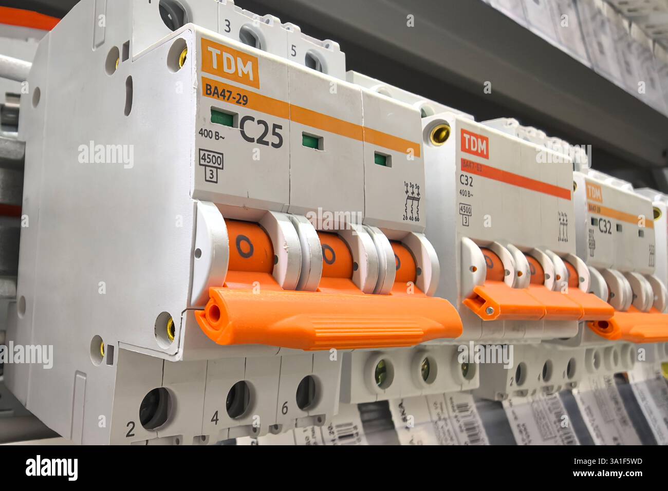 Bobruisk, Biélorussie - 22 février 2025 : dans une quincaillerie animée, un ensemble de disjoncteurs électriques est soigneusement organisé sur les étagères. Banque D'Images