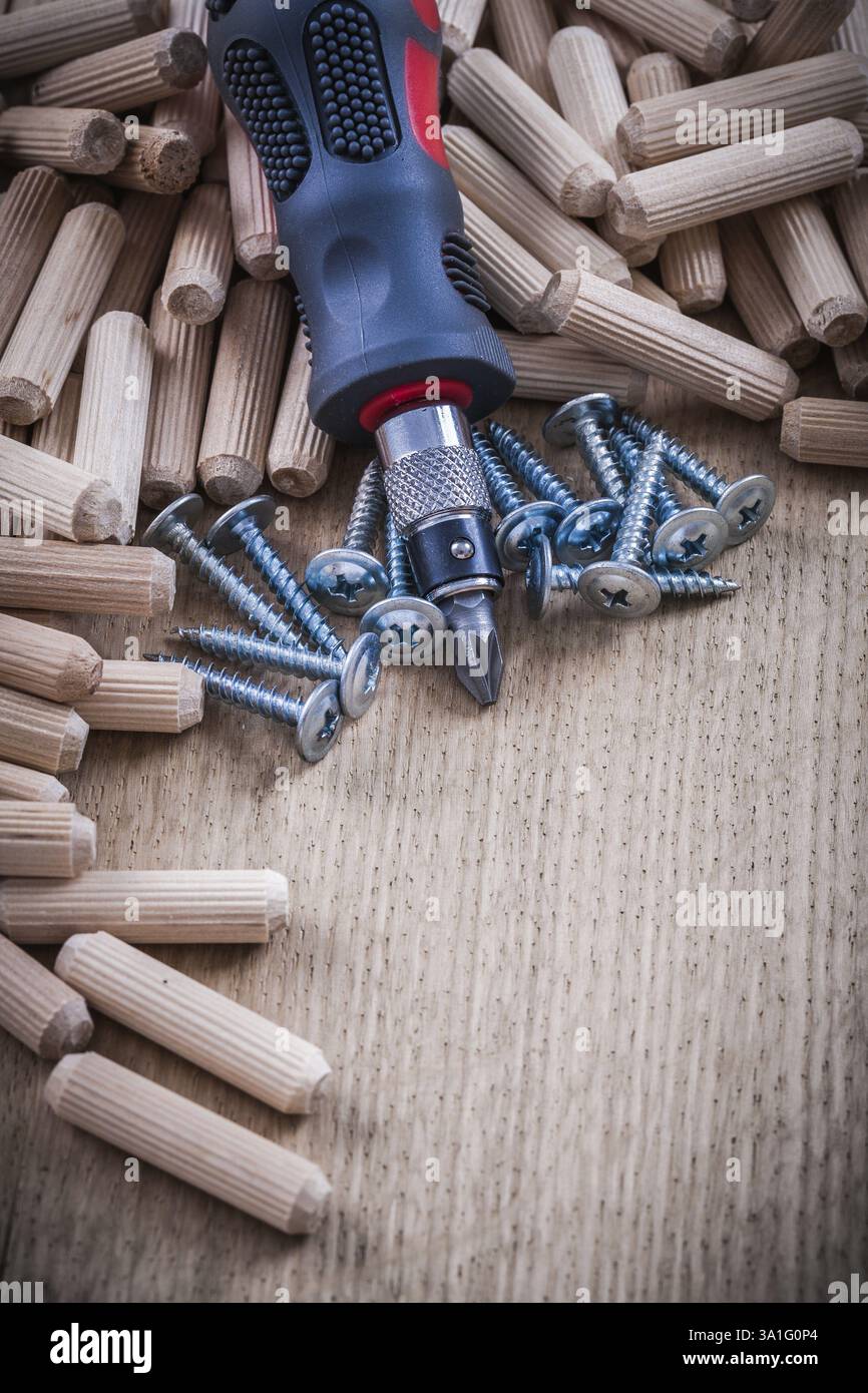 Tas de chevilles en bois, clous de construction inoxydable et tournevis isolé Banque D'Images