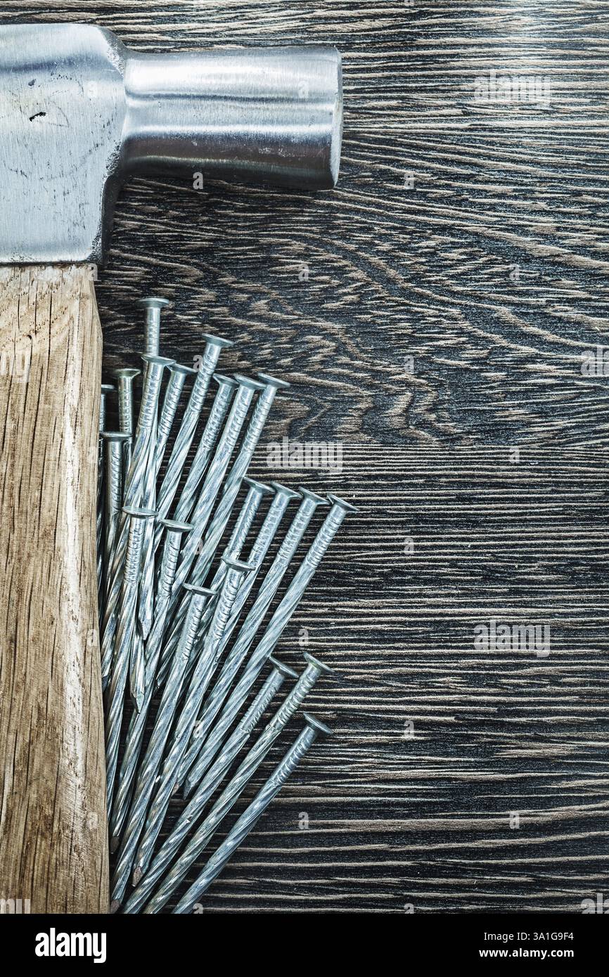 Tas de clous de construction marteau de griffe sur planche de bois Banque D'Images