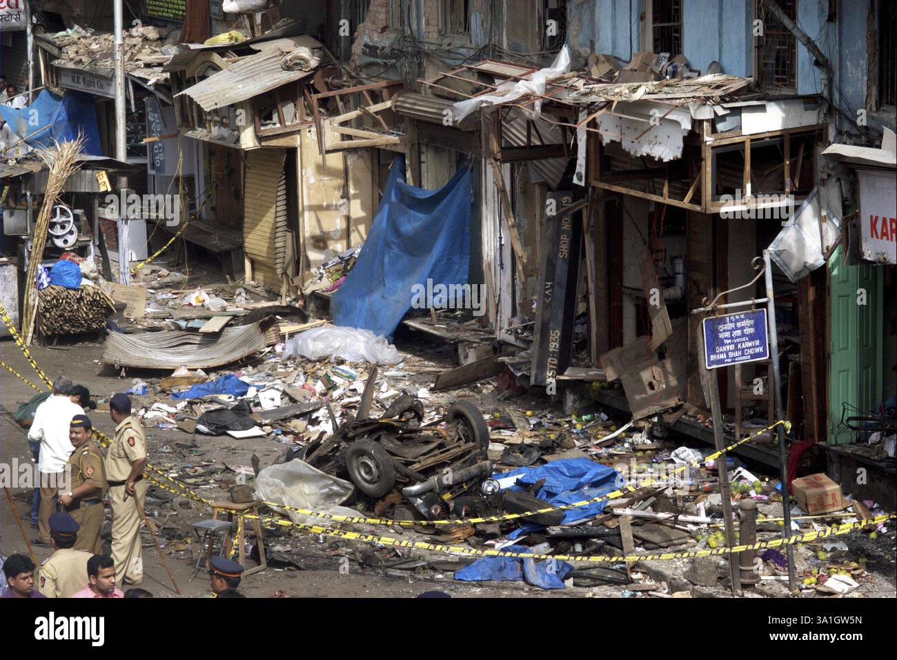 Policiers inspectant les restes de taxis endommagés par de puissants explosifs au bazar de Zaveri dans la zone animée de Kalbadevi, Bombay Mumbai, Maharashtra, Inde août Banque D'Images