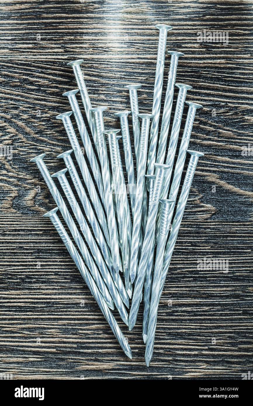 Tas de clous de construction sur planche de bois Banque D'Images