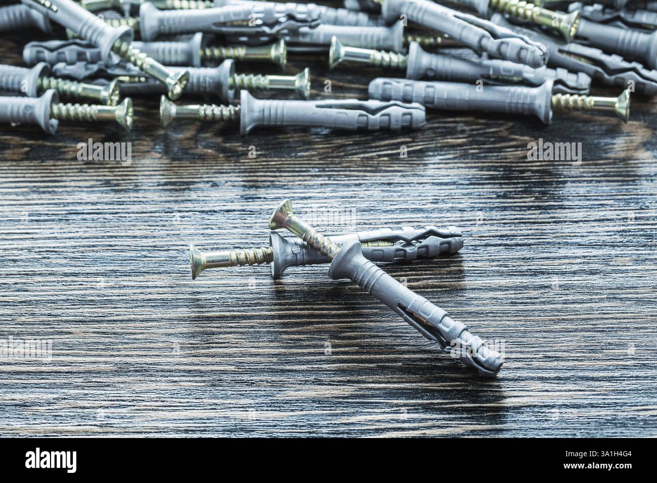 Tas de clous de cheville en plastique sur planche de bois Banque D'Images