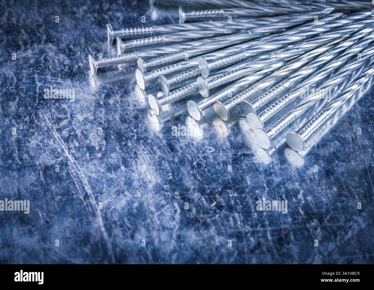 Groupe de clous de construction inoxydable sur le concept de construction de fond métallique rayé Banque D'Images