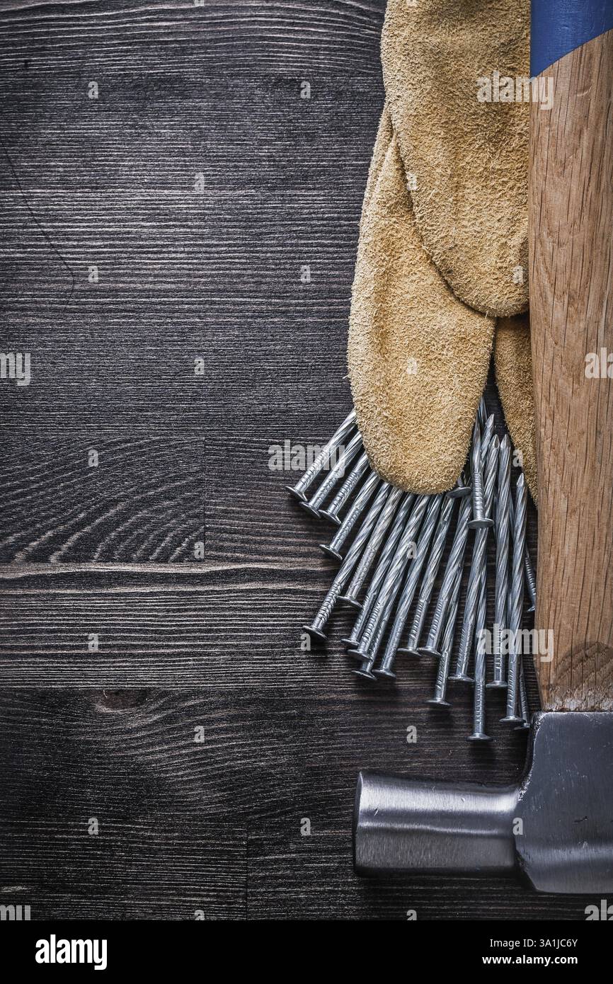 Gants de sécurité en cuir construction clous marteau à griffes sur planche de bois Banque D'Images