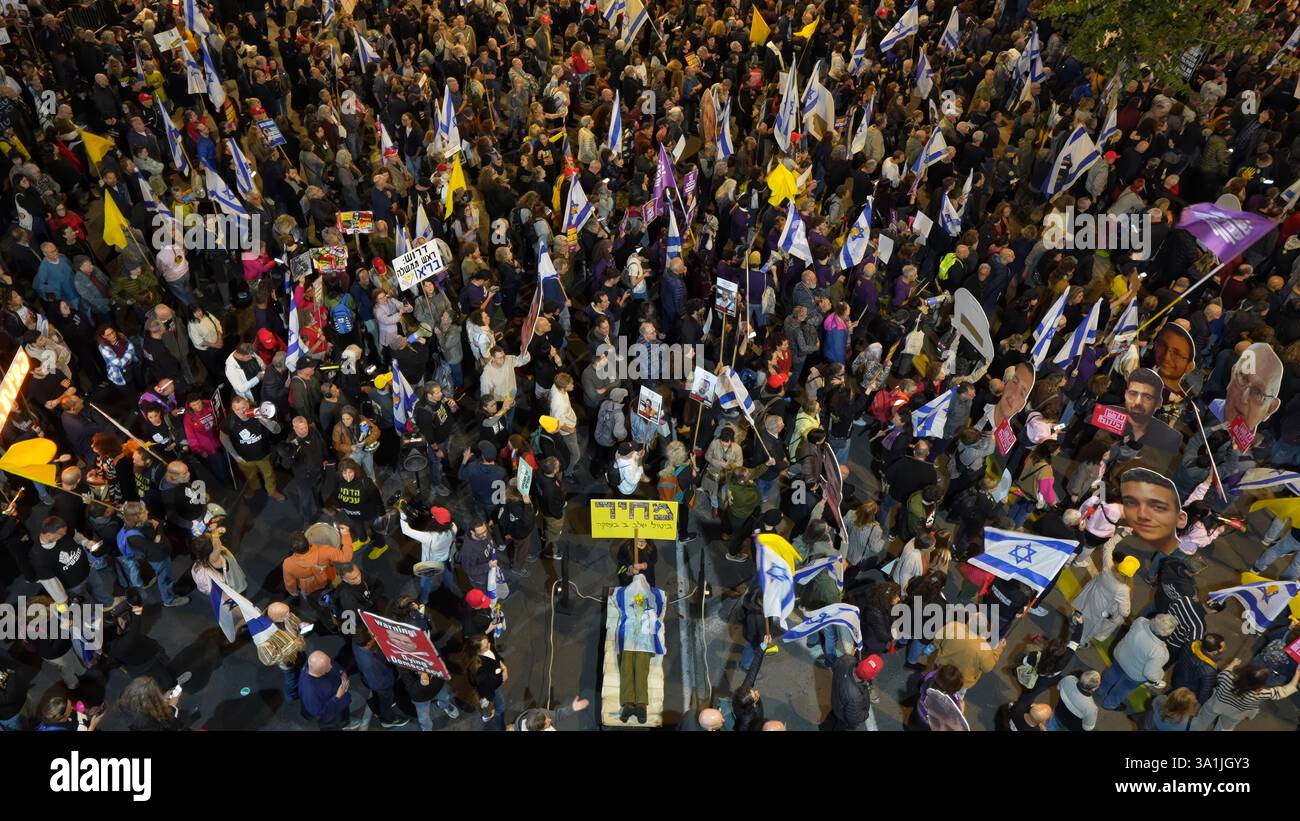 TEL AVIV, ISRAËL - 8 MARS : des manifestants tiennent des drapeaux israéliens autour d'un mannequin représentant un cadavre couvert d'un drapeau lors d'une manifestation de masse devant le siège du ministère de la Défense appelant à la conclusion de l'accord de cessez-le-feu avec le Hamas et exigeant la libération des otages restants détenus dans la bande de Gaza le 8 mars 2025 à tel Aviv, en Israël. Banque D'Images