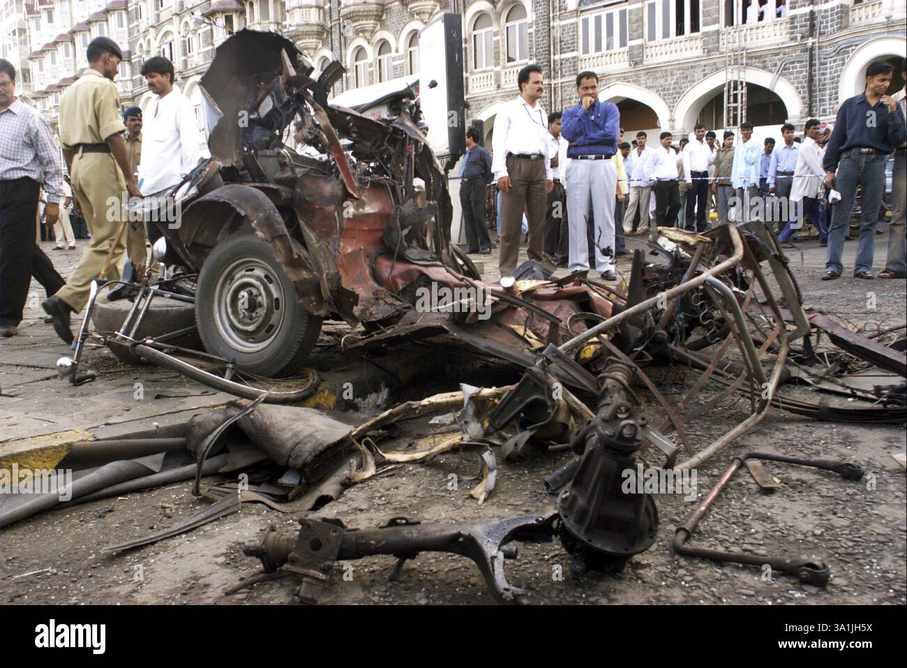 Des policiers inspectent les restes de taxis endommagés par de puissants explosifs stationnés sur le parking près de Gateway of India, Bombay Mumbai, Maharashtra, Inde Banque D'Images