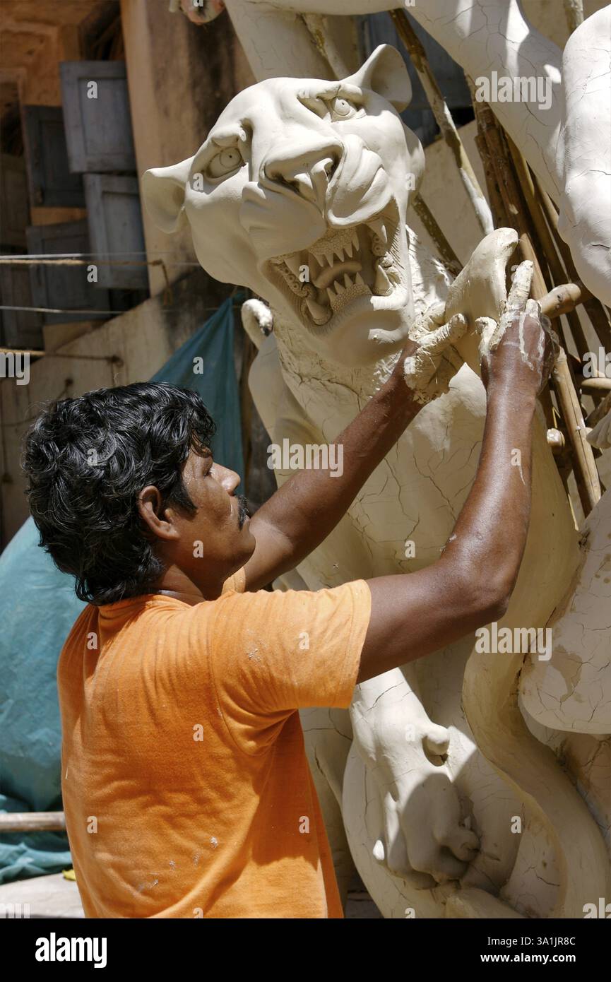 Sculpteur faisant Sinha Vahini Lion Riding déesse Durga Kali sculpture utilisant de l'argile pour la préparation de Durga Pooja, Rajkot, Gujarat, Inde, Asie Banque D'Images