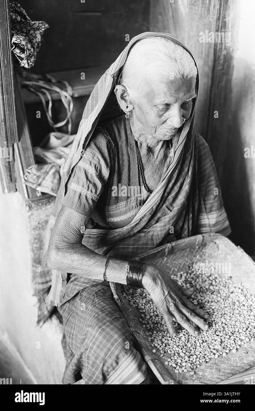 Vieille femme nettoyant les céréales, village de Lokur, district de Dharwar, Karnataka, Inde, Asie Banque D'Images Vieille femme nettoyant les céréales, village de Lokur, district de Dharwar, Karnataka, Inde, Asie Banque D'Images