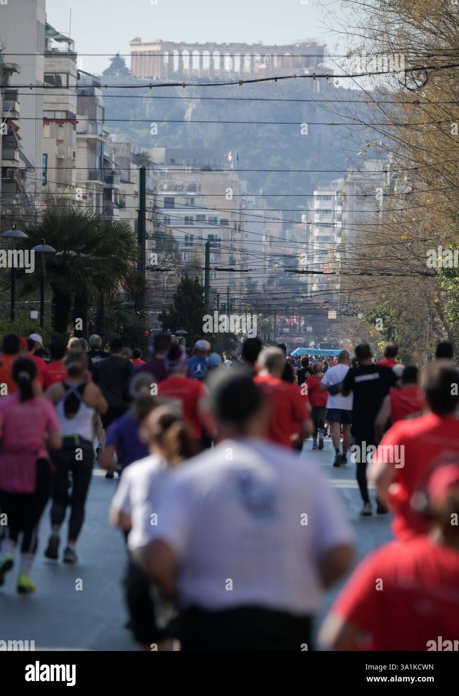 Athènes, Grèce, 9 mars 2025. Les concurrents font leur chemin dans Patision Avenue tandis que l'Acropole peut être vu en arrière-plan. Des milliers de citoyens ont participé au grand événement sportif, le 13ème semi-marathon d’Athènes, qui a commencé dans le centre de la capitale. Crédit : Dimitris Aspiotis/Alamy Live News Banque D'Images